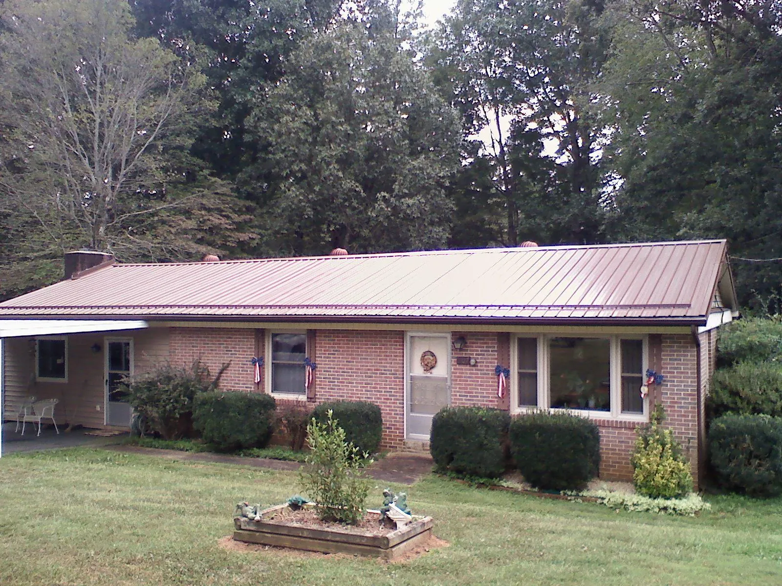 Bronze metal roof on a brick ranch home with a carport in Gardendale