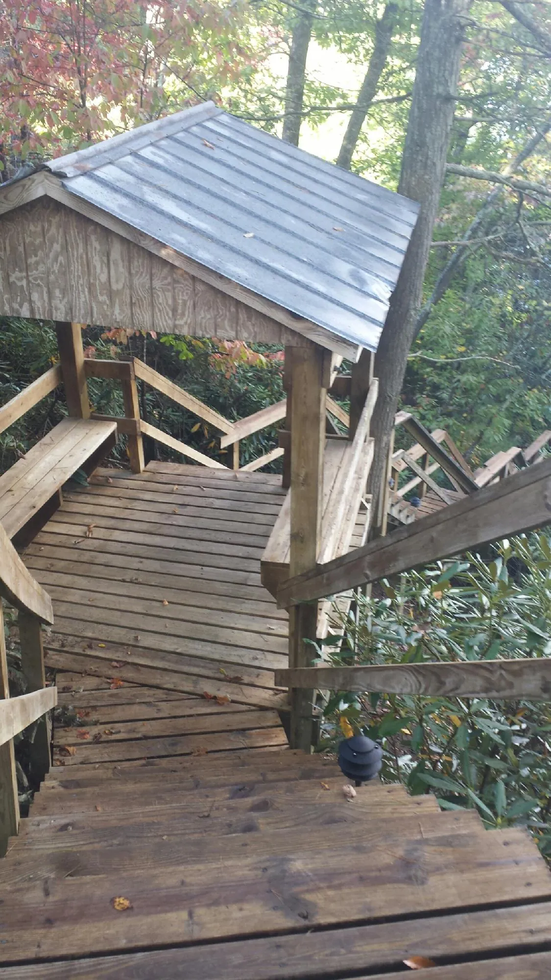 Metal roofed shelter over wooden steps on a wooded walkway — Skylight Repair & Installation work by our crew in Gardendale