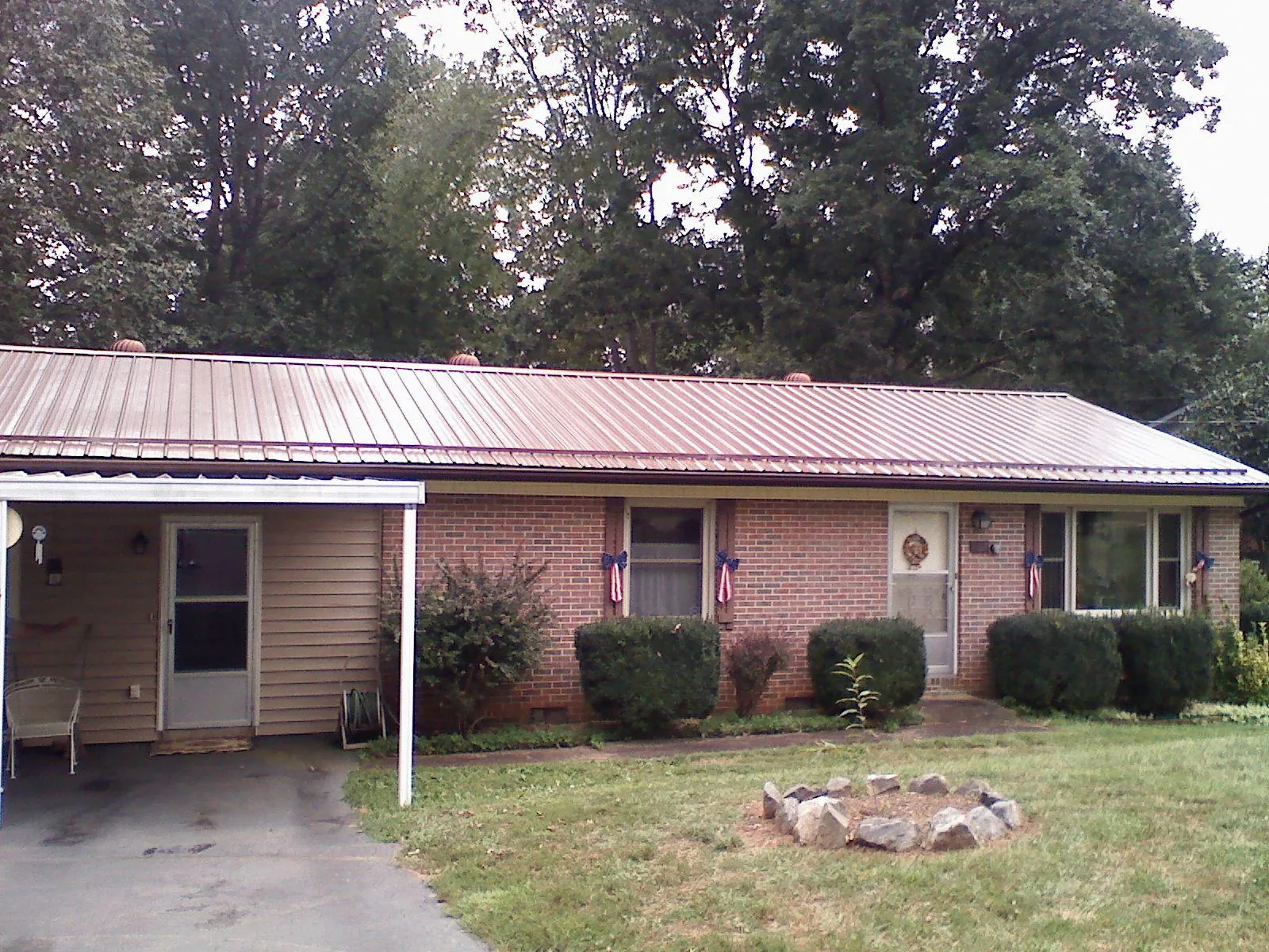 Bronze metal roof and carport on a brick ranch home — Roof Repair work by our crew in Gardendale