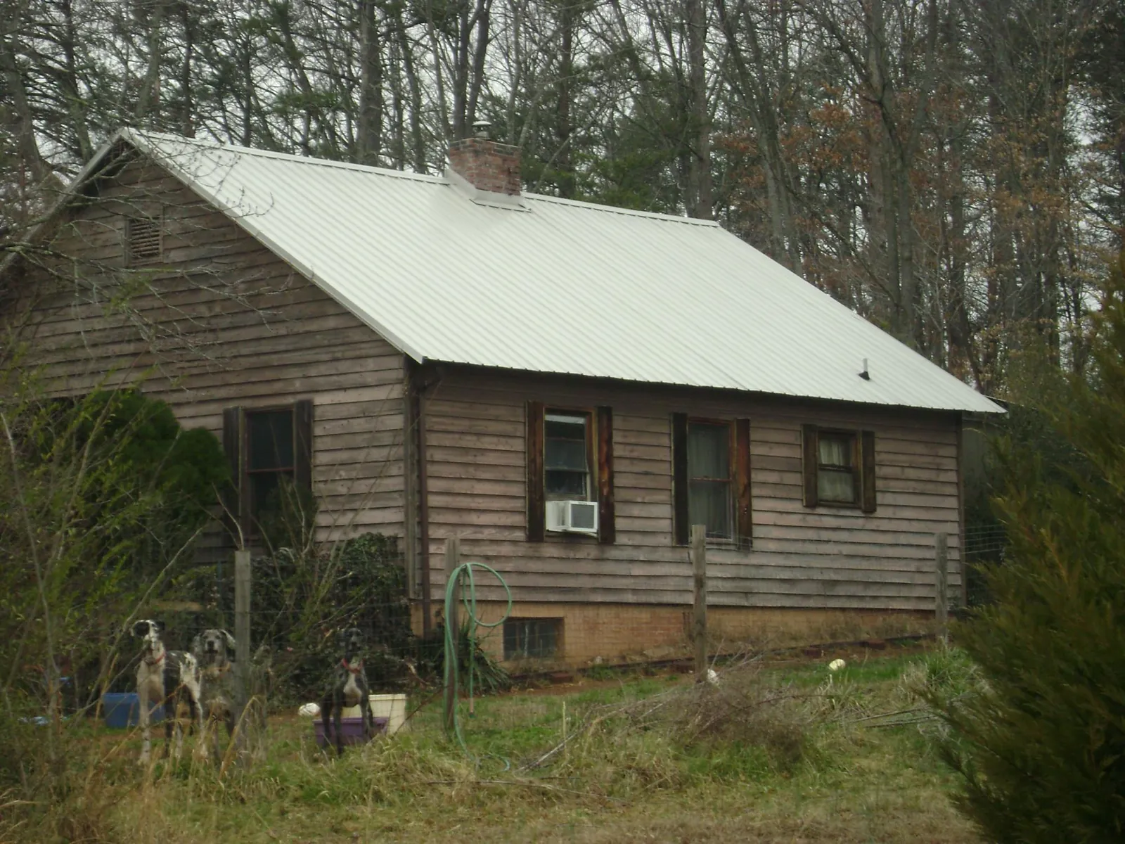 White metal roof on an old wood sided farmhouse, from a Metal Roof Installation job in Gardendale